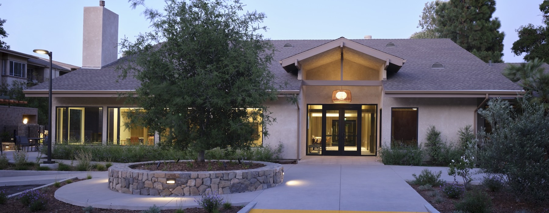 a building with a sidewalk and trees