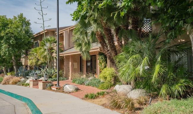 a building with a sidewalk and trees